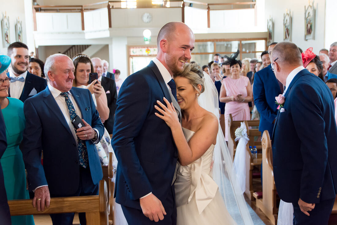 Clare Wedding Photographer | A bride and groom have a hug at the first look on the alter