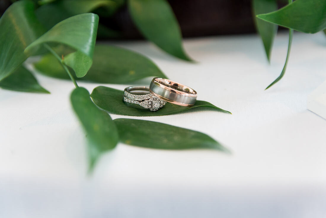 Clare Wedding Photographer photographs wedding rings on a leaf