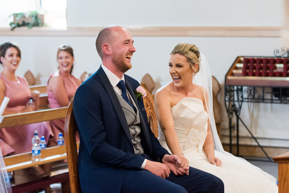 Clare Wedding Photographer | A bride and groom laugh at the alter