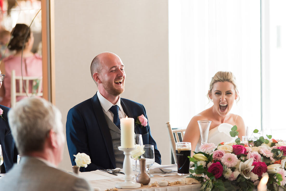 A laughing bride and groom on their wedding day in The Armada Hotel in County Clare